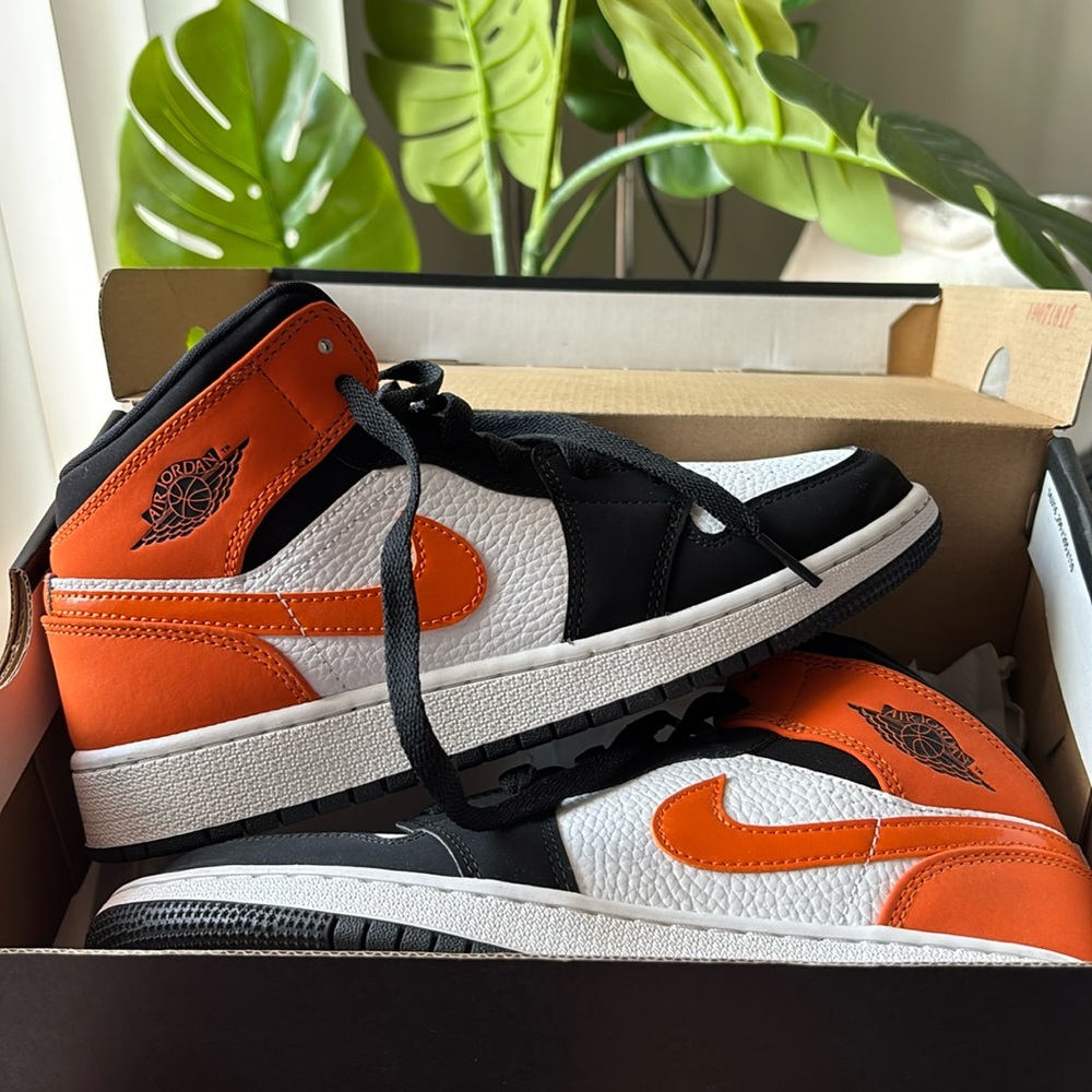Air Jordan mid 1 (grade school) orange and black. Boys size 5.5 women’s 7